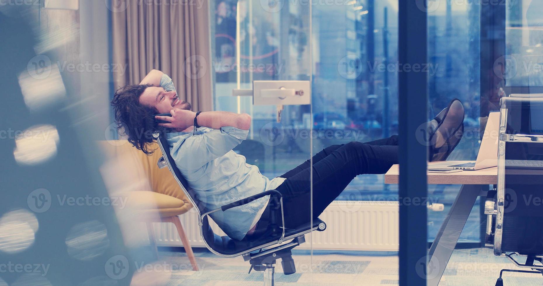 businessman sitting with legs on desk photo