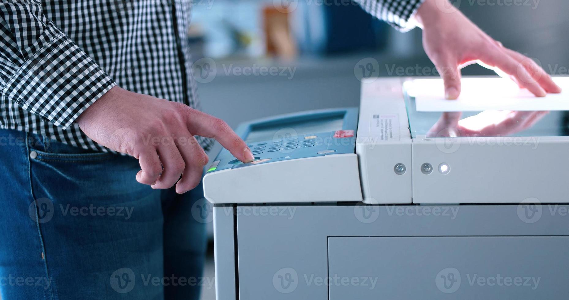 asistente masculino usando fotocopiadora en la oficina moderna foto