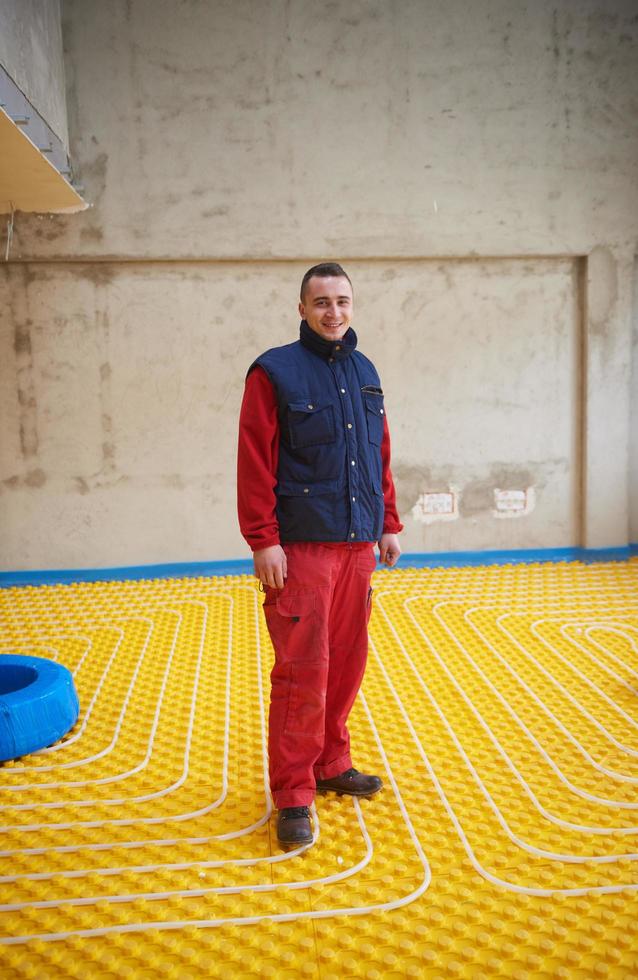 workers installing underfloor heating system photo