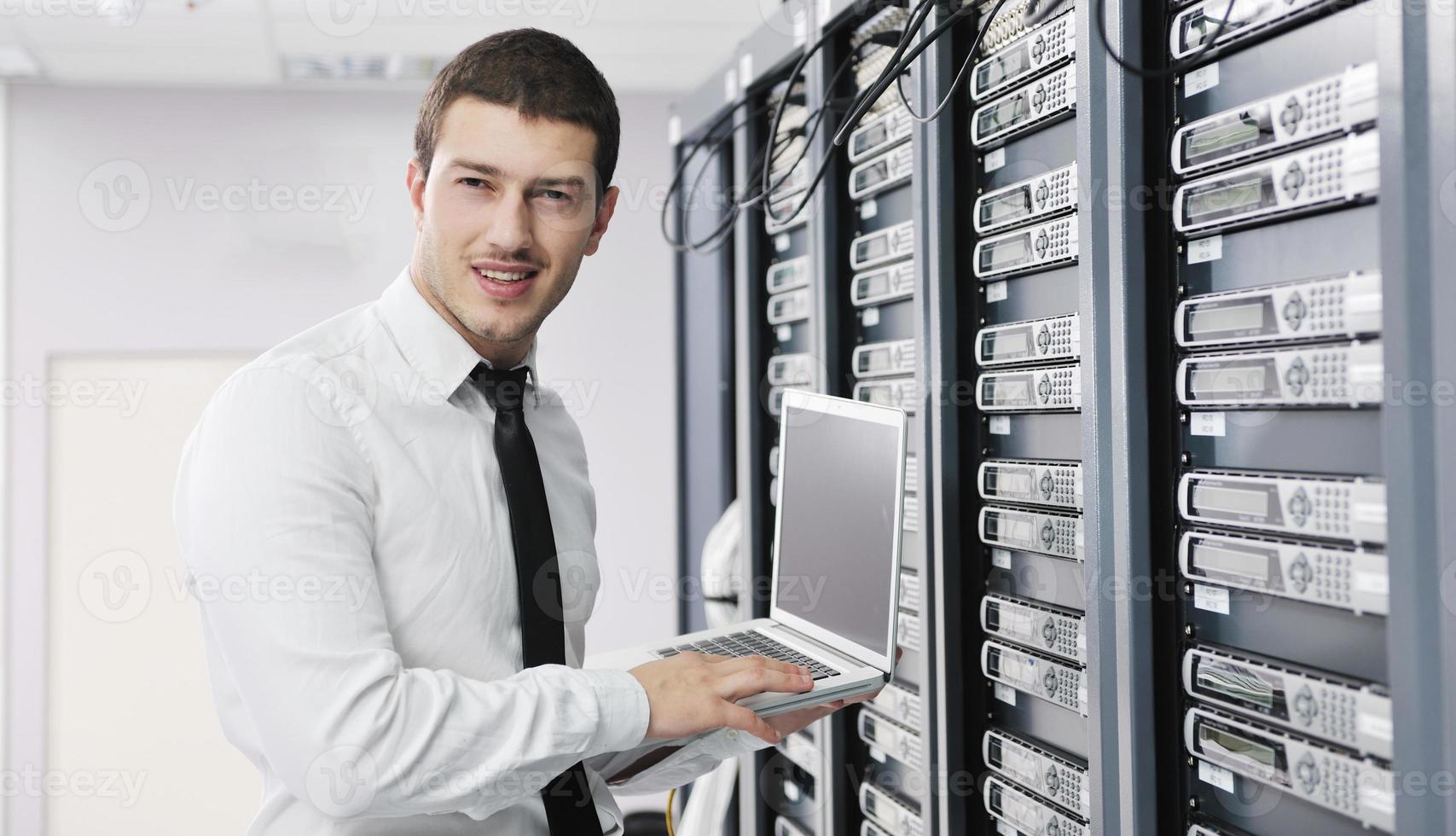 businessman with laptop in network server room photo