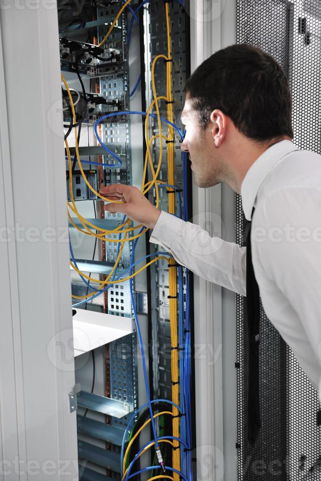 young engeneer in datacenter server room photo