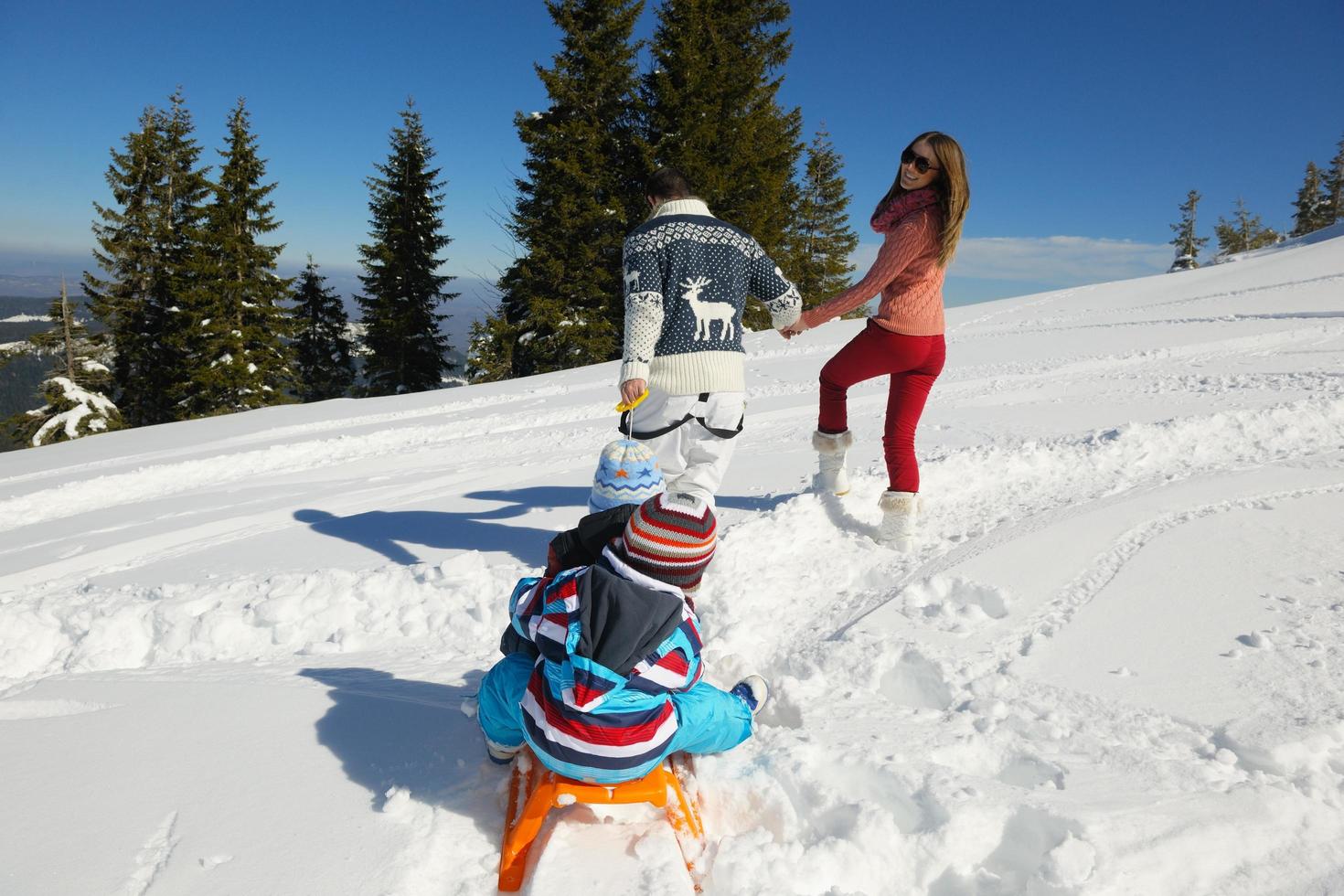 family having fun on fresh snow at winter photo