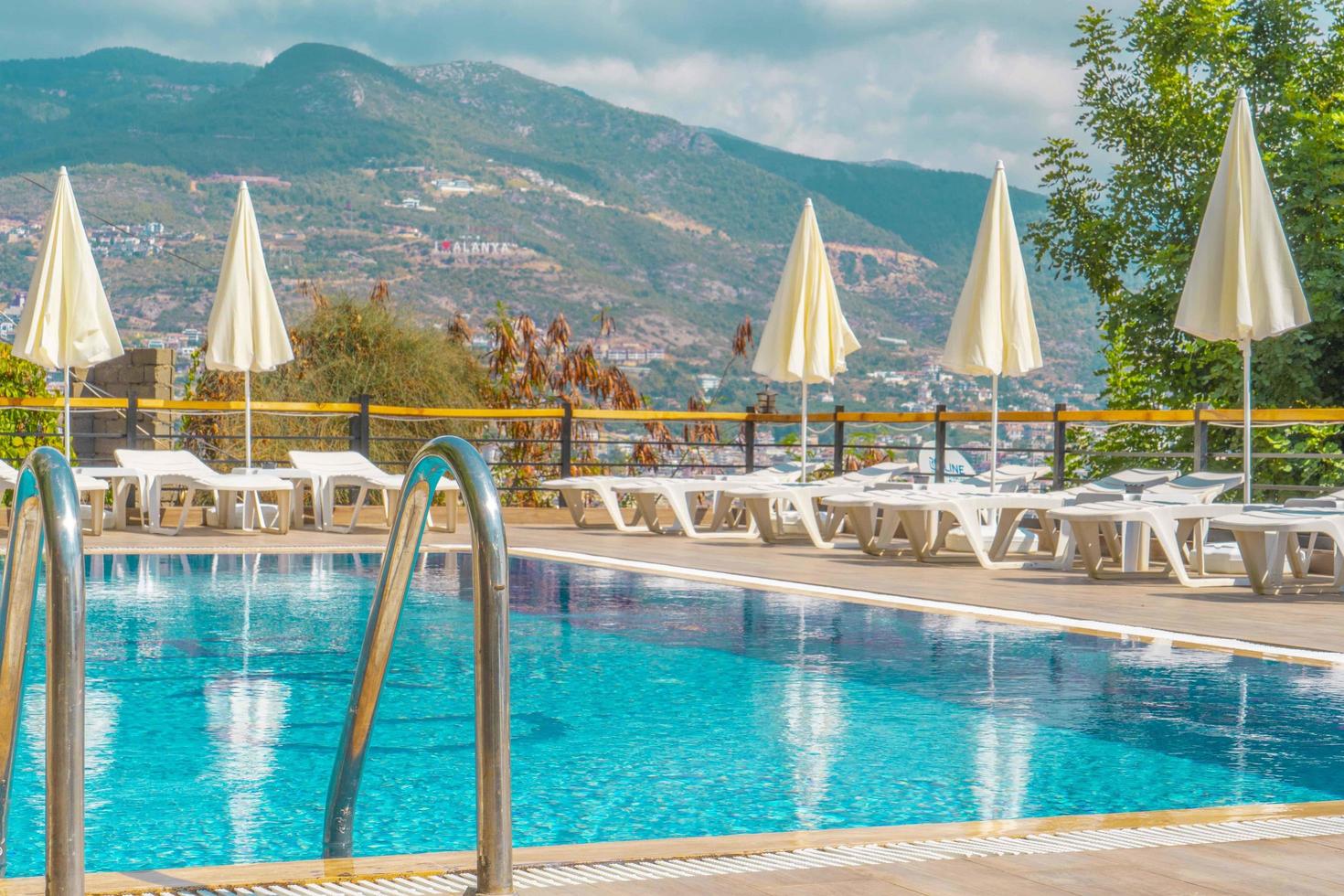 Luxurious pool in the garden of a private villa, hanging chair with pillows for leisure tourists, in summer photo