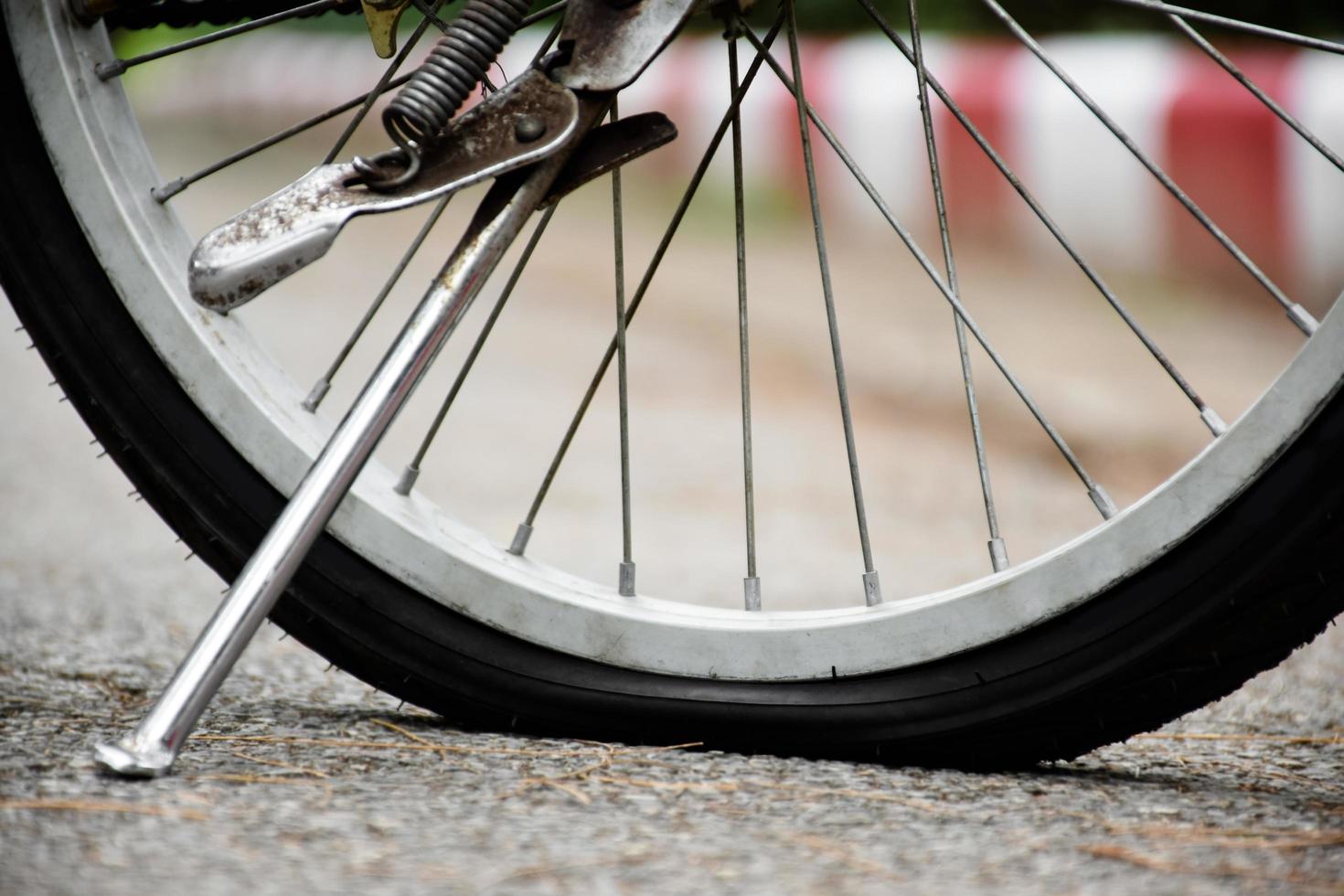 Closeup rear flat wheel of vintage bike on pavement in the evening of the day, sunset light edited, soft and selective focus photo