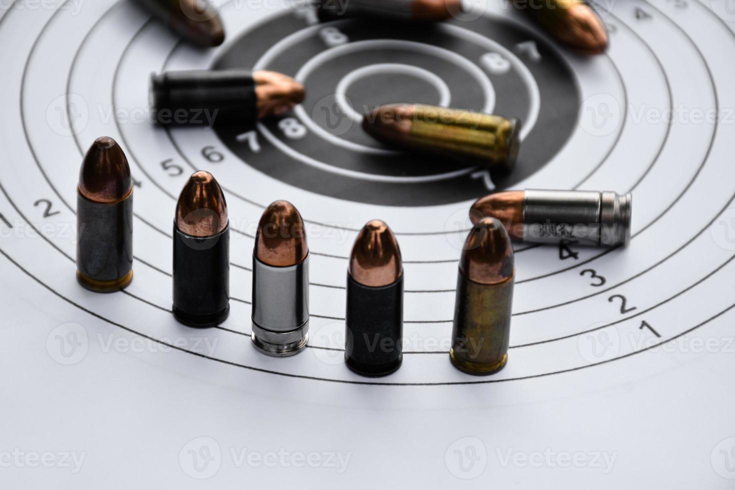 9mm pistol bullets and bullet shells on shooting target papere, soft and selectivec focus. photo