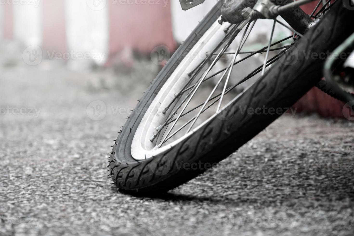 vista de cerca de la llanta pinchada trasera de una bicicleta antigua que estacionó en el pavimento al lado de la carretera. enfoque suave y selectivo. foto