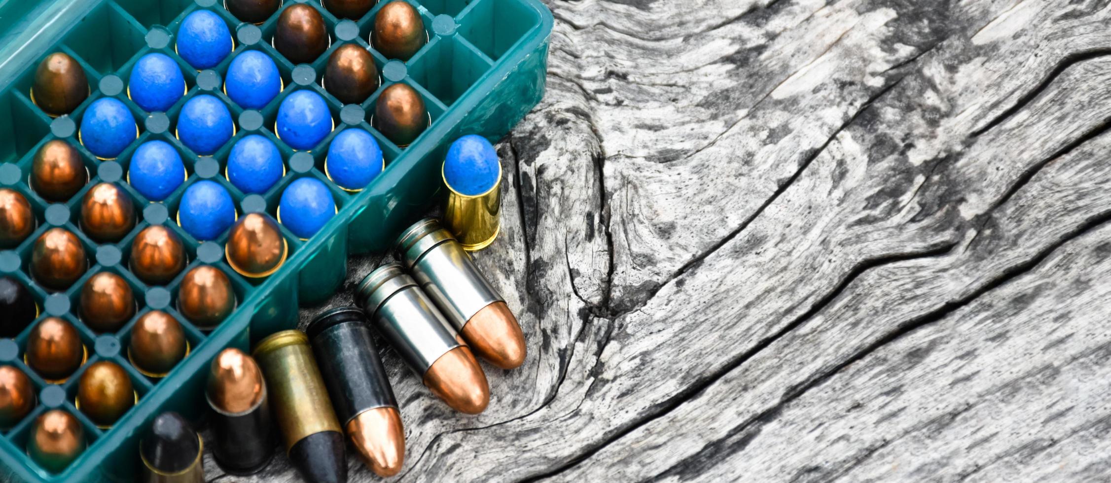 9mm pistol bullets and bullet shells on wooden table, soft and selectivec focus. photo