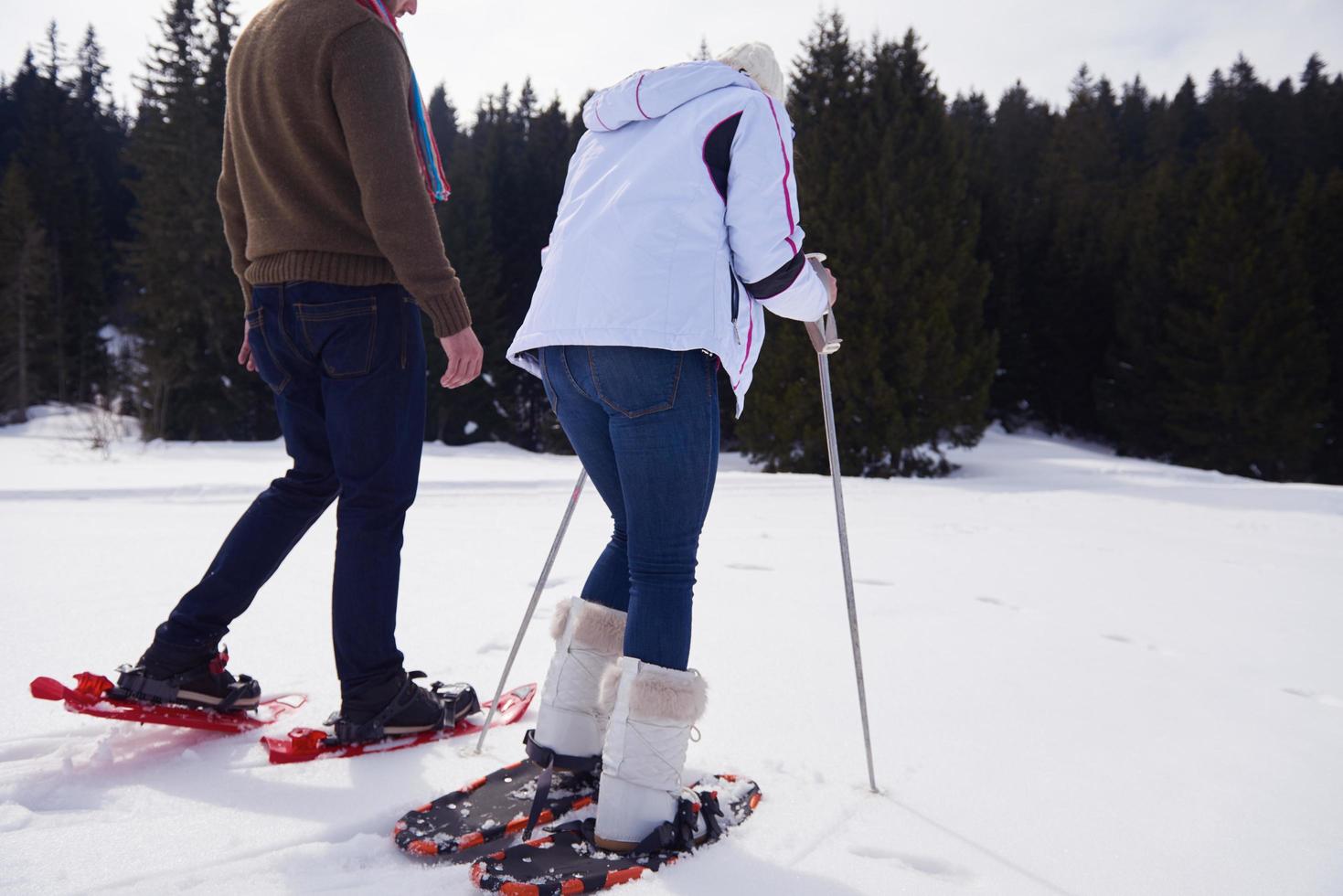 couple having fun and walking in snow shoes photo