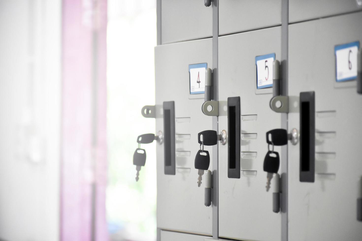 Metal filing cabinets for storing student supplies in classroom, soft and selective focus on black key. photo