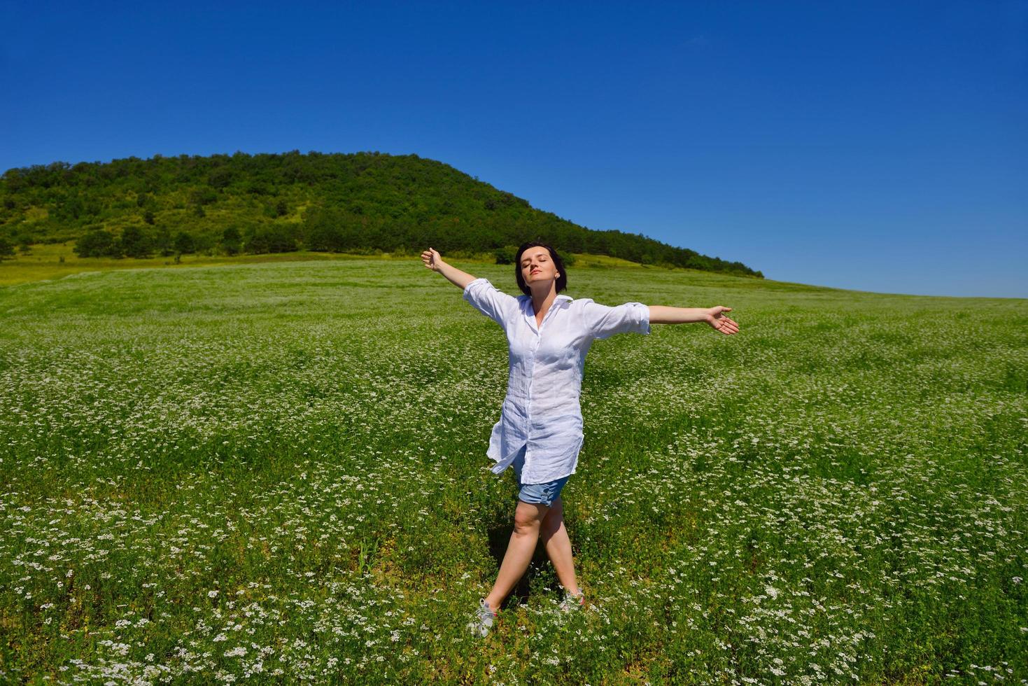young woman with spreading arms to sky photo