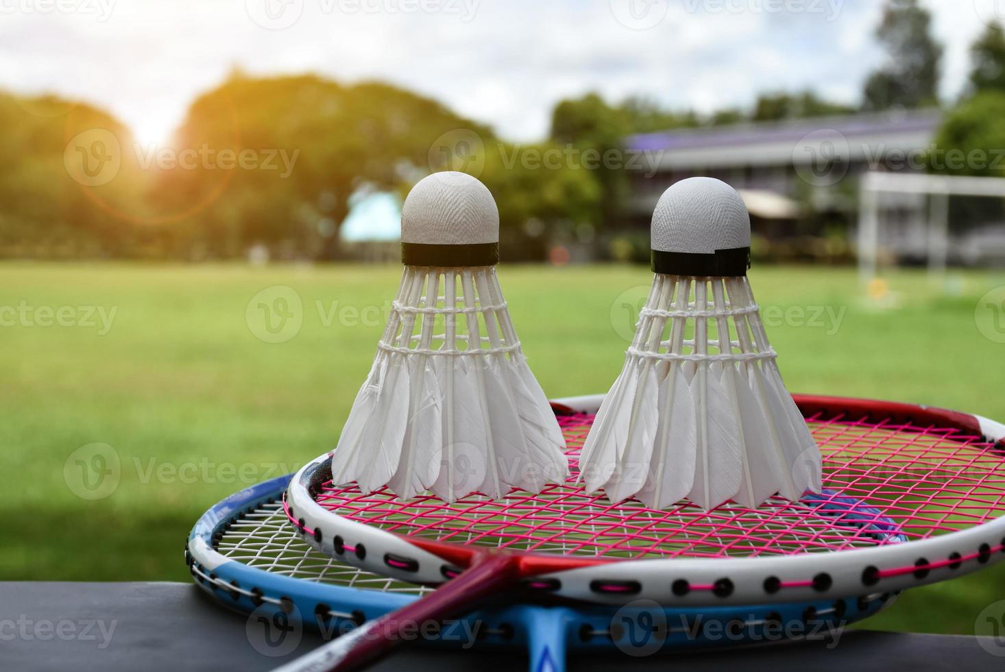 Badminton racket and badminton shuttlecock against cloudy and bluesky background, outdoor badminton playing concept. selective focus on racket. photo