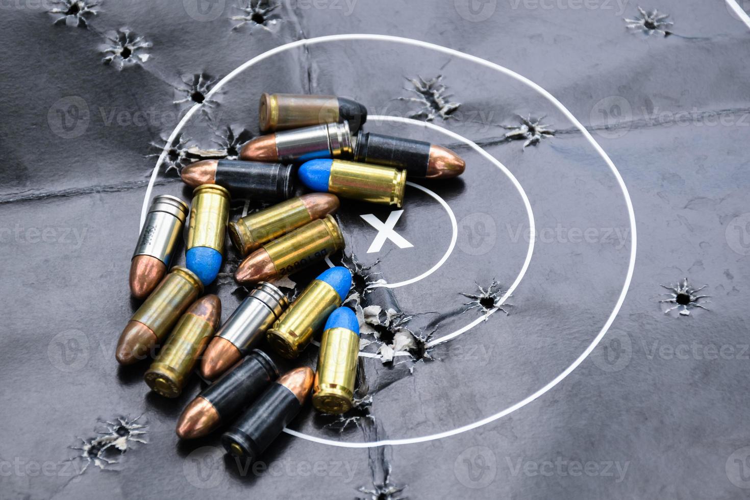 9mm pistol bullets and bullet shells on shooting target papere, soft and selectivec focus. photo