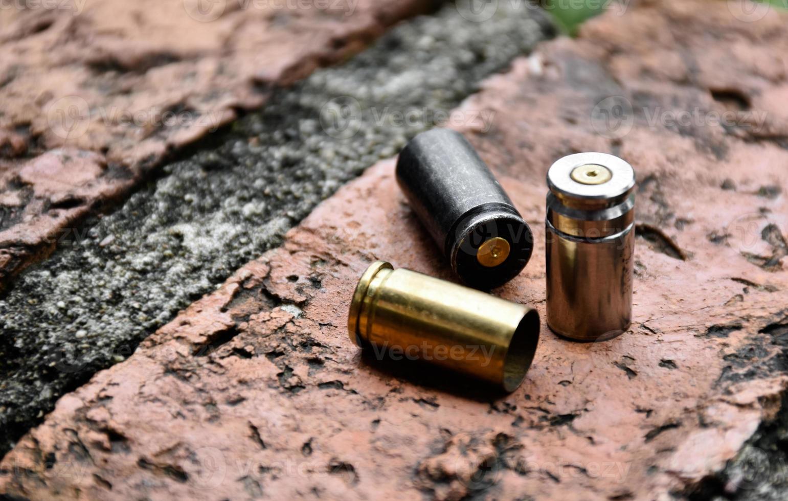 Proyectiles de bala de pistola de 9 mm en suelo de ladrillo, enfoque suave y selectivo, concepto para buscar una pieza clave de evidencia en un caso de asesinato en la escena. foto