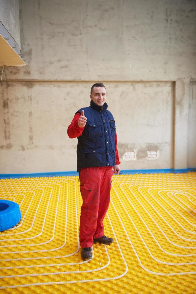 workers installing underfloor heating system photo