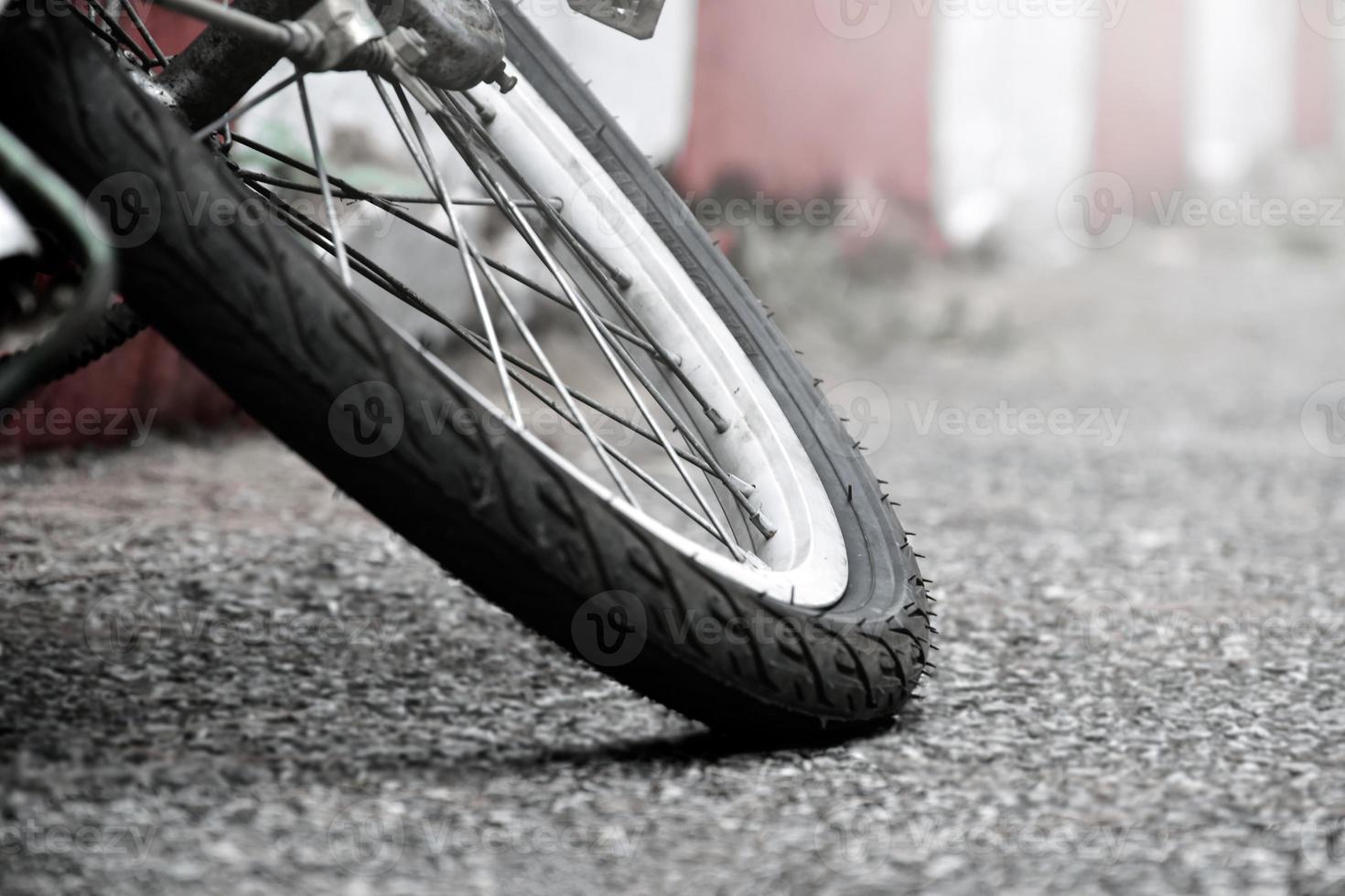 vista de cerca de la llanta pinchada trasera de una bicicleta antigua que estacionó en el pavimento al lado de la carretera. enfoque suave y selectivo. foto