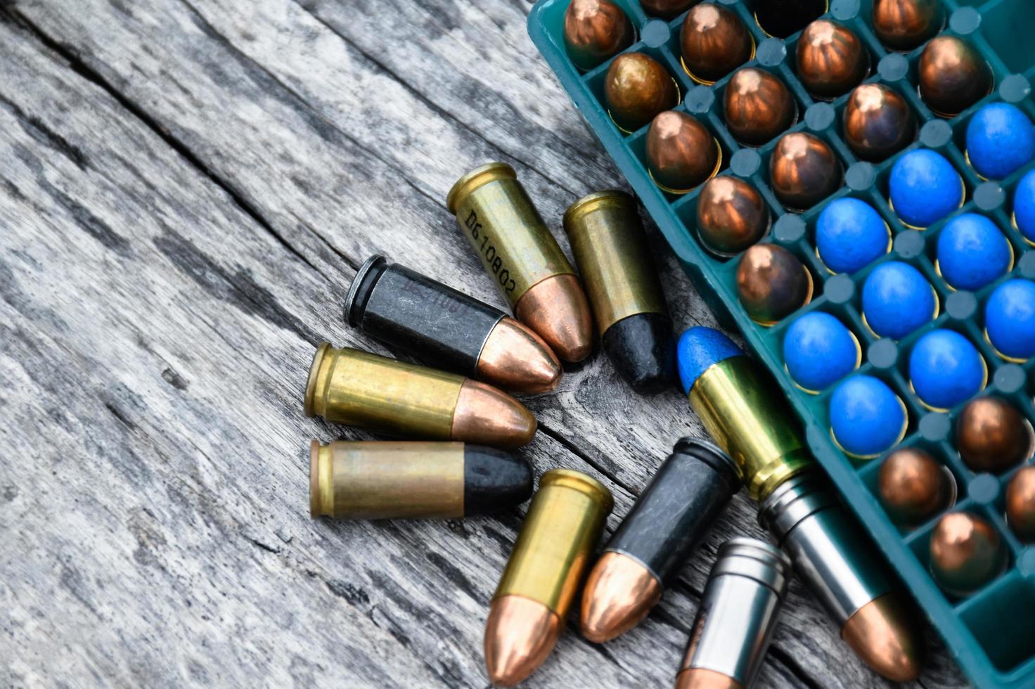 9mm pistol bullets and bullet shells on wooden table, soft and selectivec focus. photo