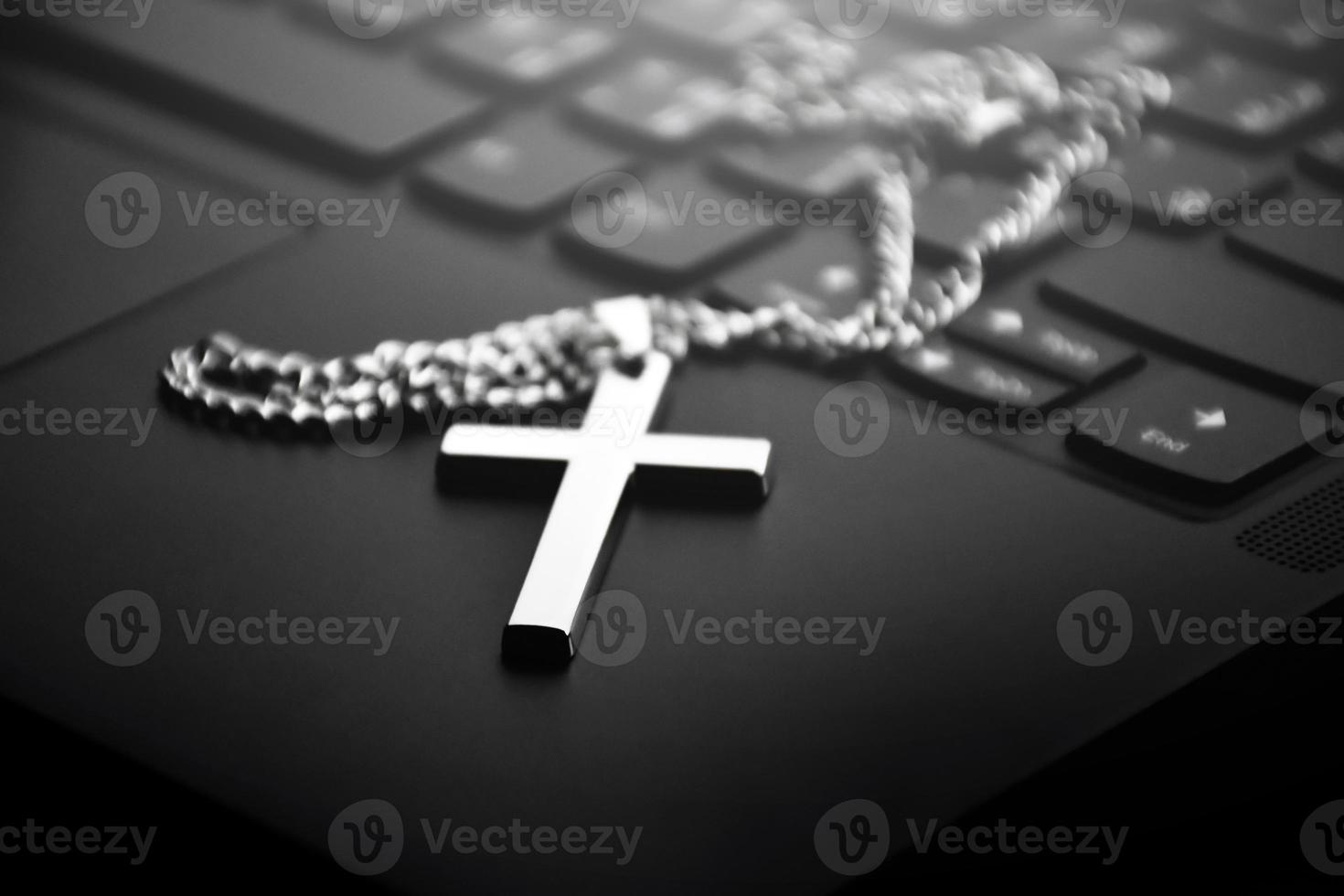collar cruzado de metal en el teclado del portátil, enfoque suave y selectivo en el collar cruzado. foto