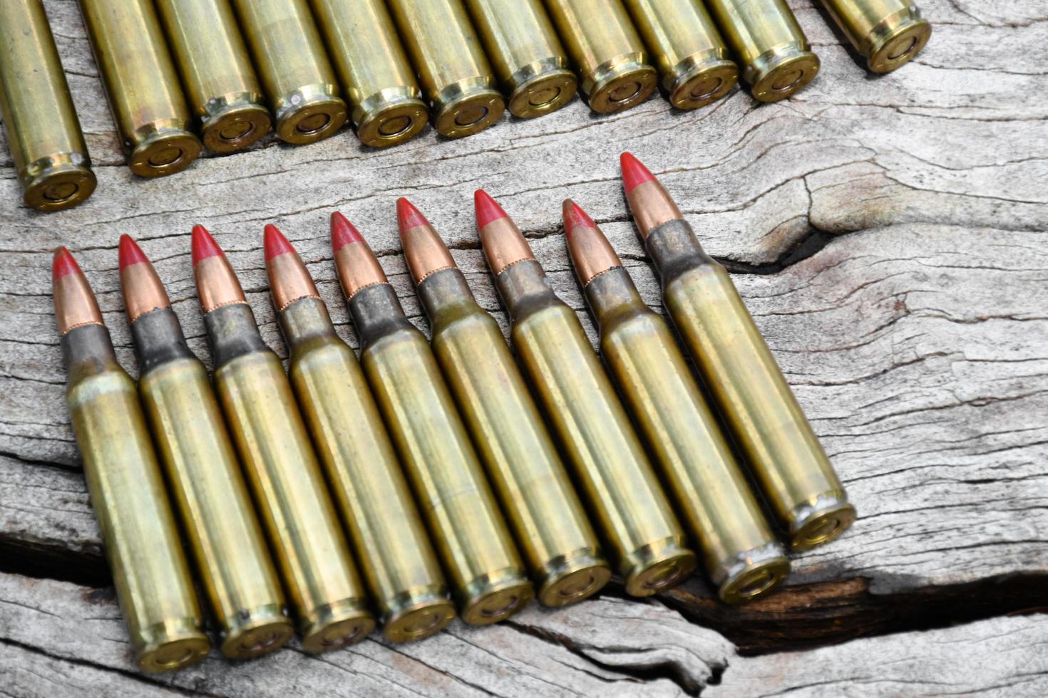 Pile of old bullets on wooden plank and jeans, soft and selective focus. photo