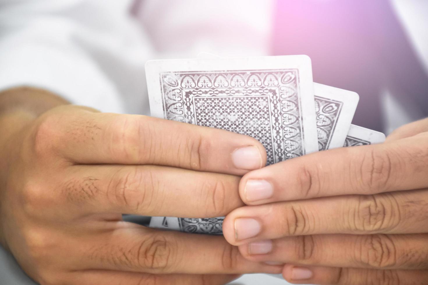Poker paper cards in hands of woman who sitting and playing card with friend, soft and selective focus, freetimes and hobby activity at home concept. photo