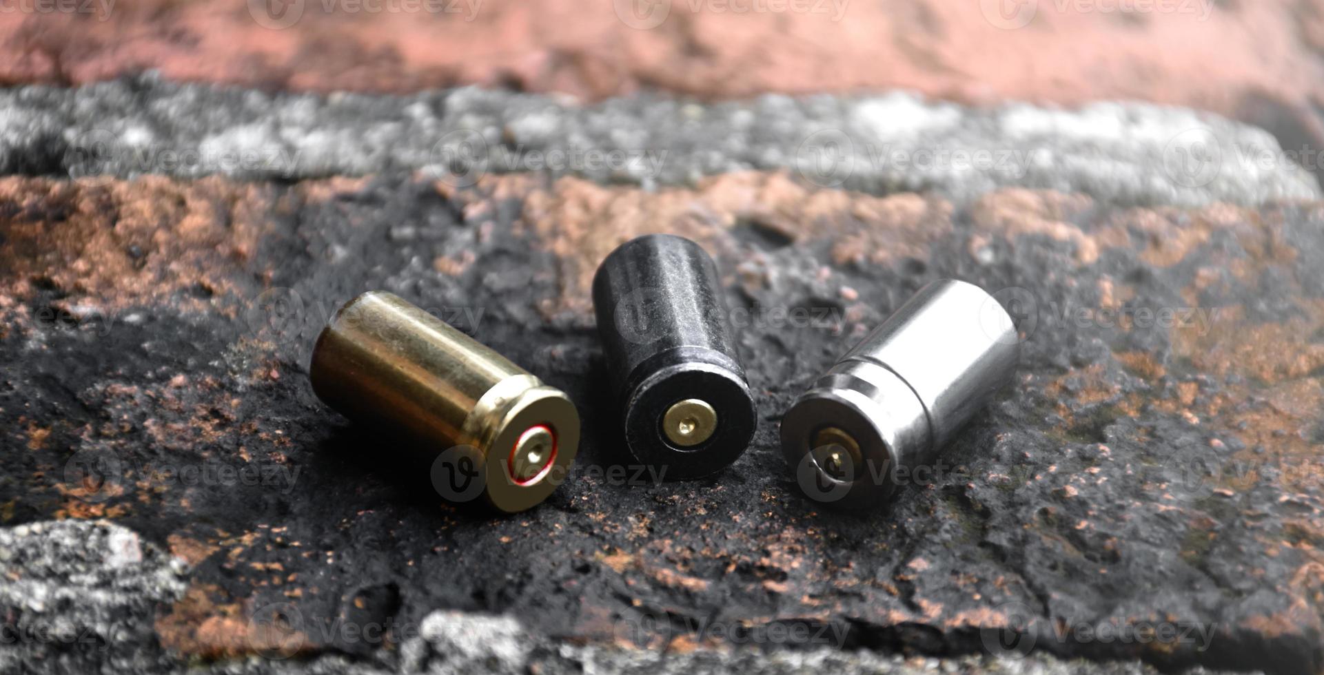 9mm pistol bullets and bullet shells on brick floor, soft and selectivec focus. photo