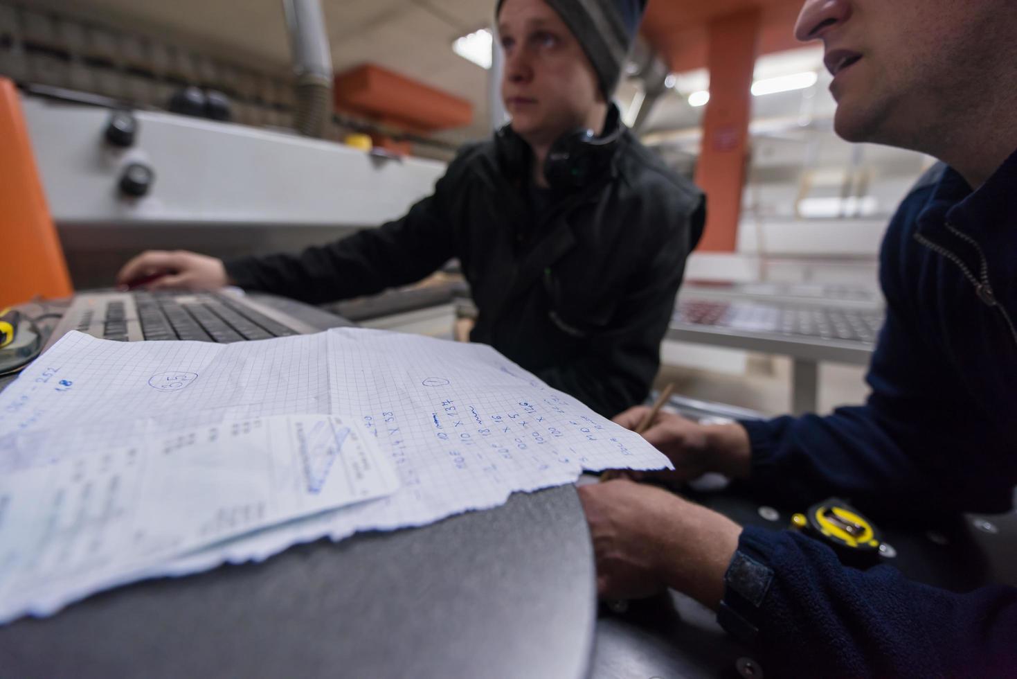 carpinteros calculando y programando una máquina de trabajo de madera cnc foto