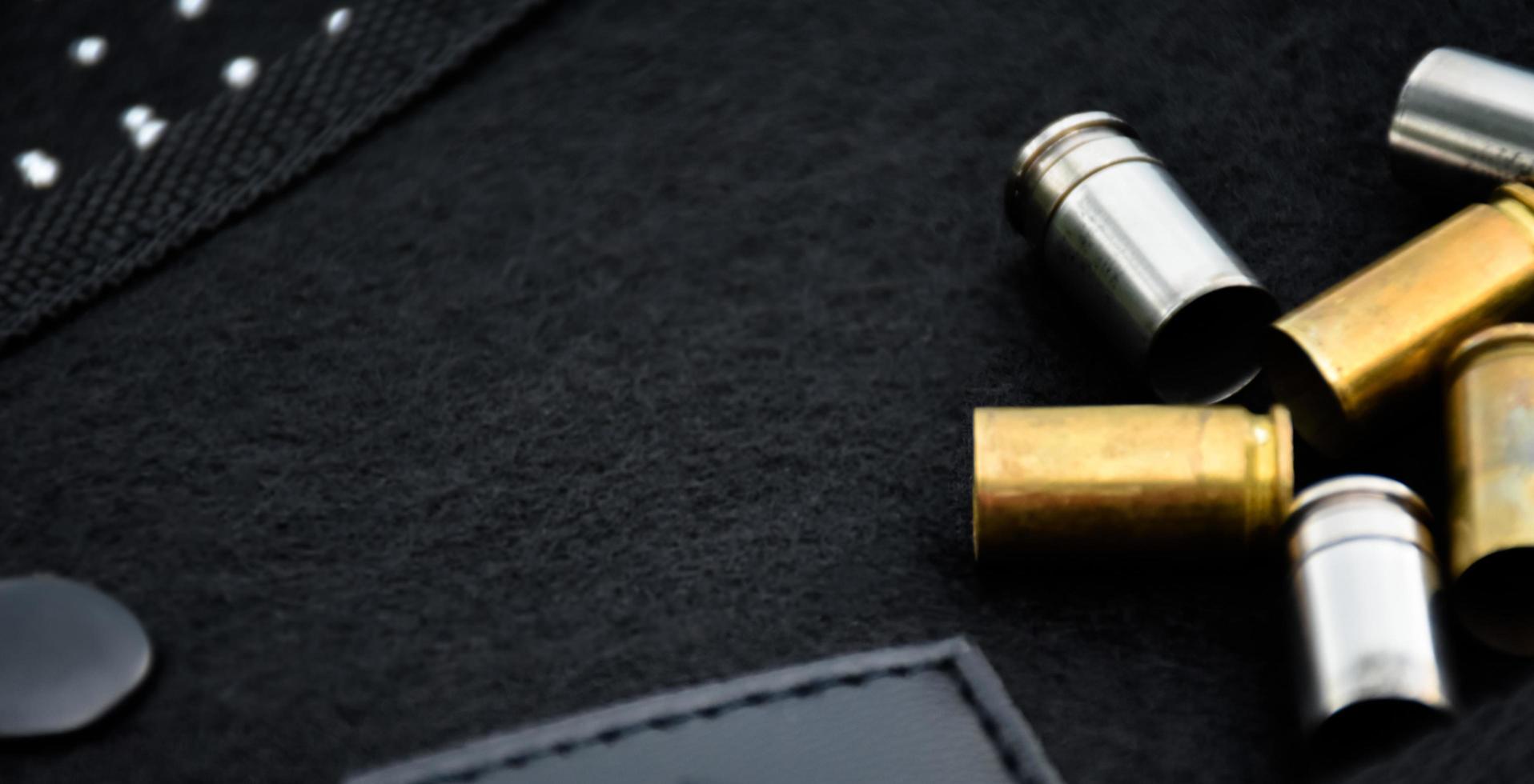 9mm pistol bullets and bullet shells on black leather background, soft and selectivec focus. photo