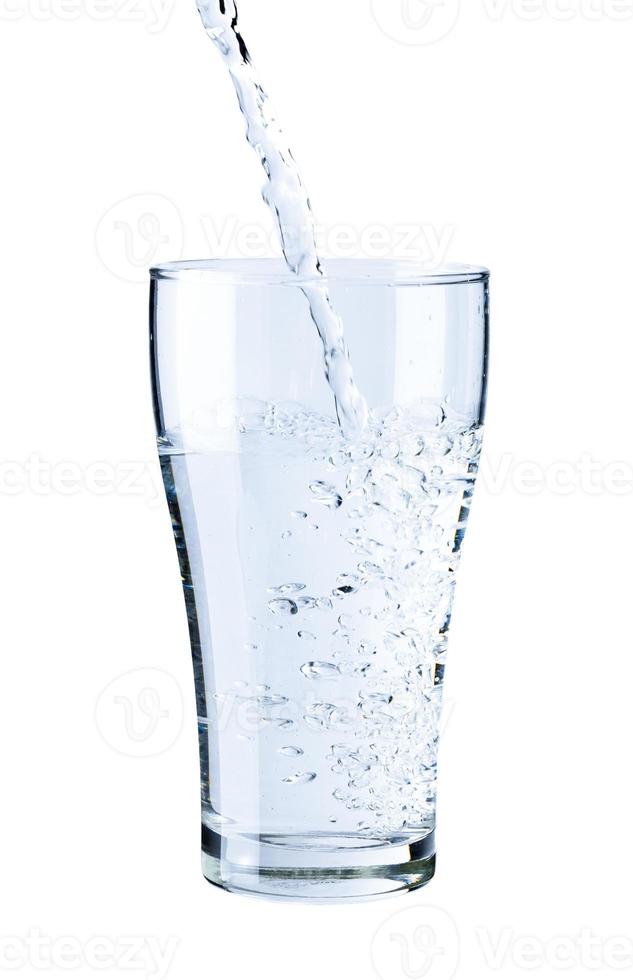 verter agua pura fresca en un vaso aislado sobre fondo blanco, concepto de hidratación de salud y belleza foto