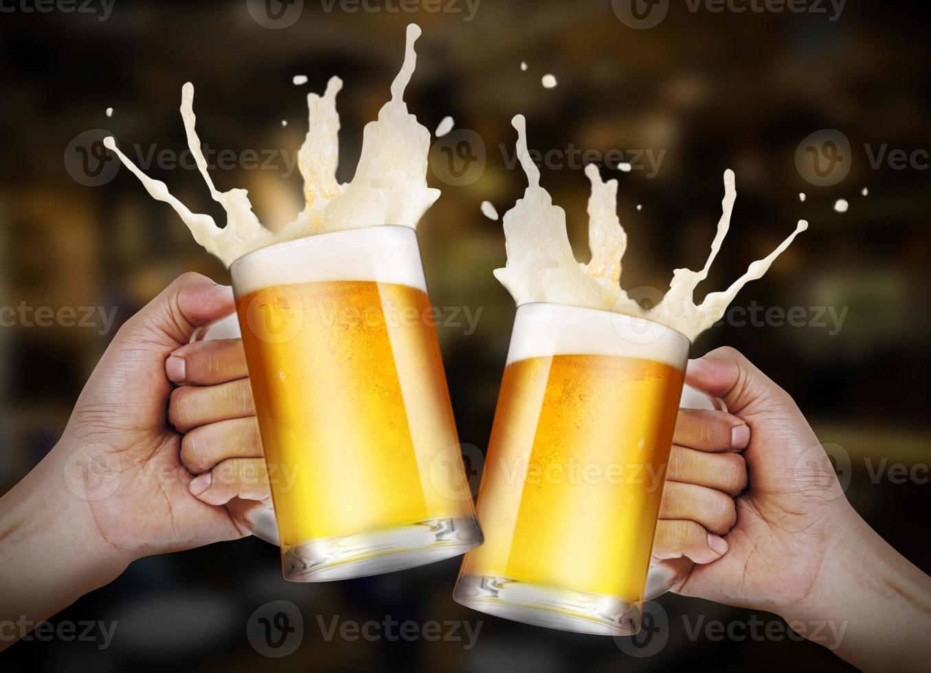 Two hands holding a glasses of light beer toasting with bubble froth splash in the restaurant background with copy space photo