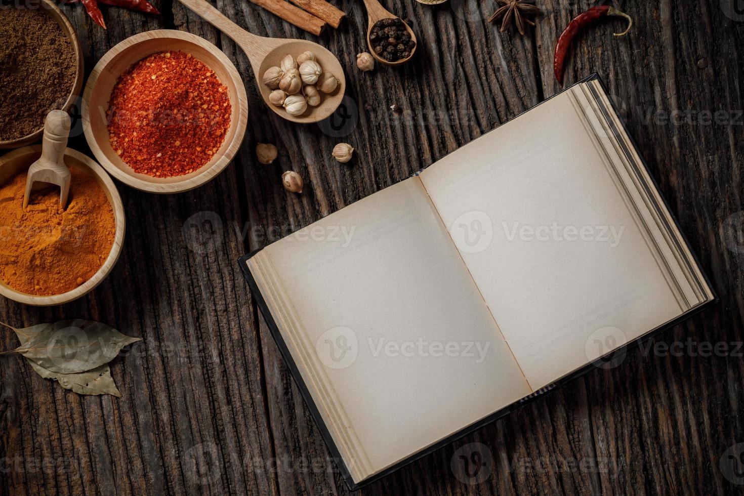 Herbs and spices and the book top view with copy space on the wooden table photo