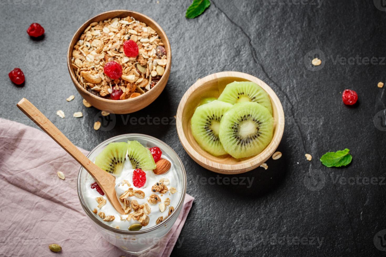 yogur casero con granola, kiwi, frutos secos y frutos secos bio - semilla más saludable. foto