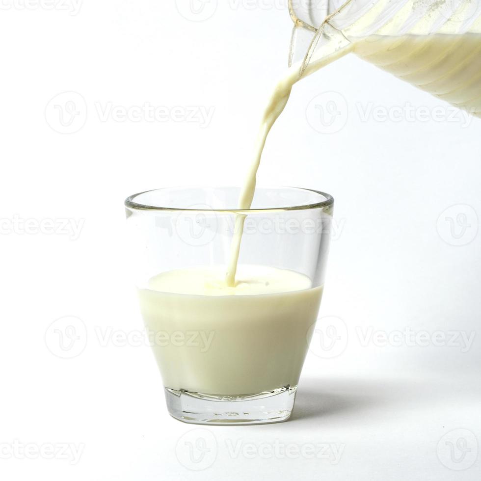 verter una taza de leche creando salpicaduras foto