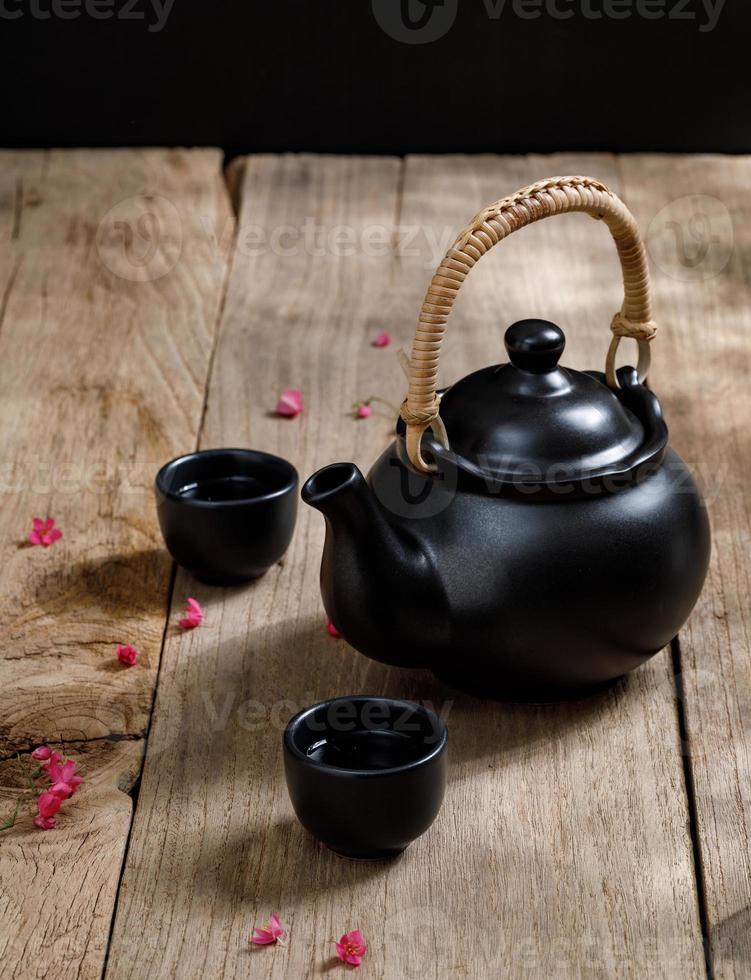 taza de té caliente con jarras humeantes en el fondo de la mesa de madera con espacio de copia para su texto, estilo chino foto