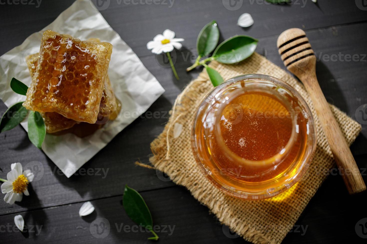 miel orgánica y panal en la mesa de madera, productos saludables por concepto de ingredientes naturales orgánicos foto