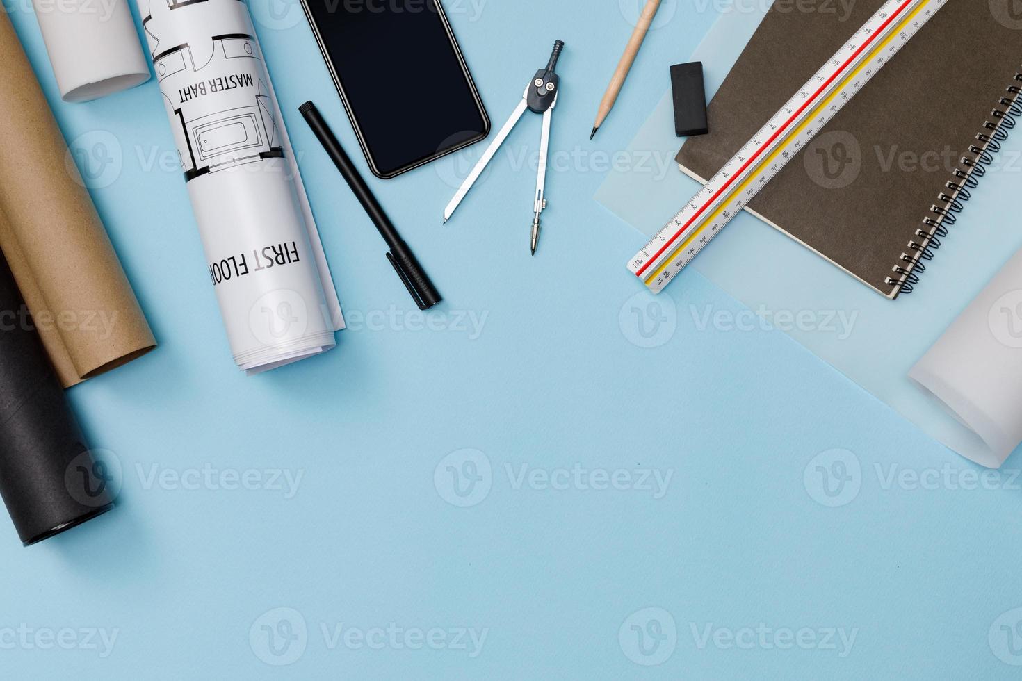 Creative flat lay of architects blue table with roll blueprints, architectural project plan, engineering tools, office supplies, isolated on blue background, Workspace for designer concept photo