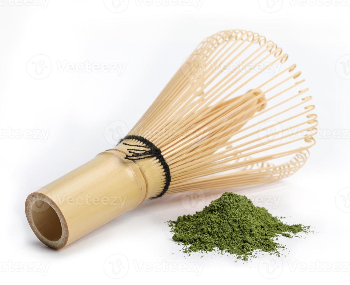 Japanese wire whisk with Heap of matcha green tea powder isolated on white background, Organic product from the nature for healthy with traditional style photo