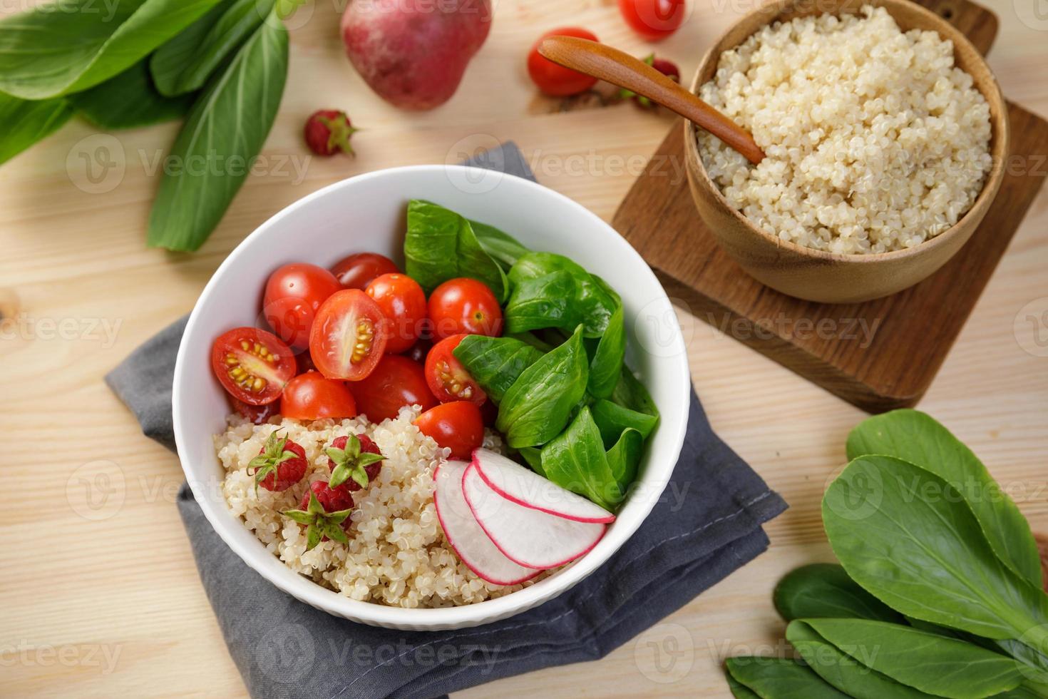 ensalada de quinua con verduras, frambuesa y tomates en la mesa de madera. súper alimento para la salud y el concepto de dieta equilibrada foto