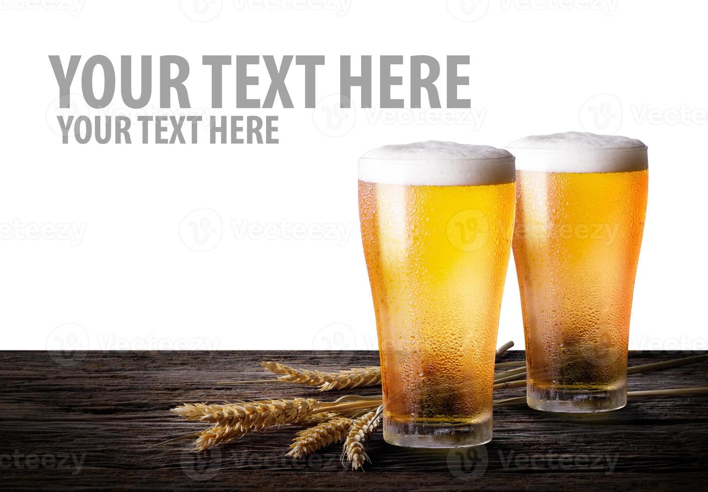 Cold beer with wheat on wooden table. Glasses of light beer on isolate white background with copy space. photo