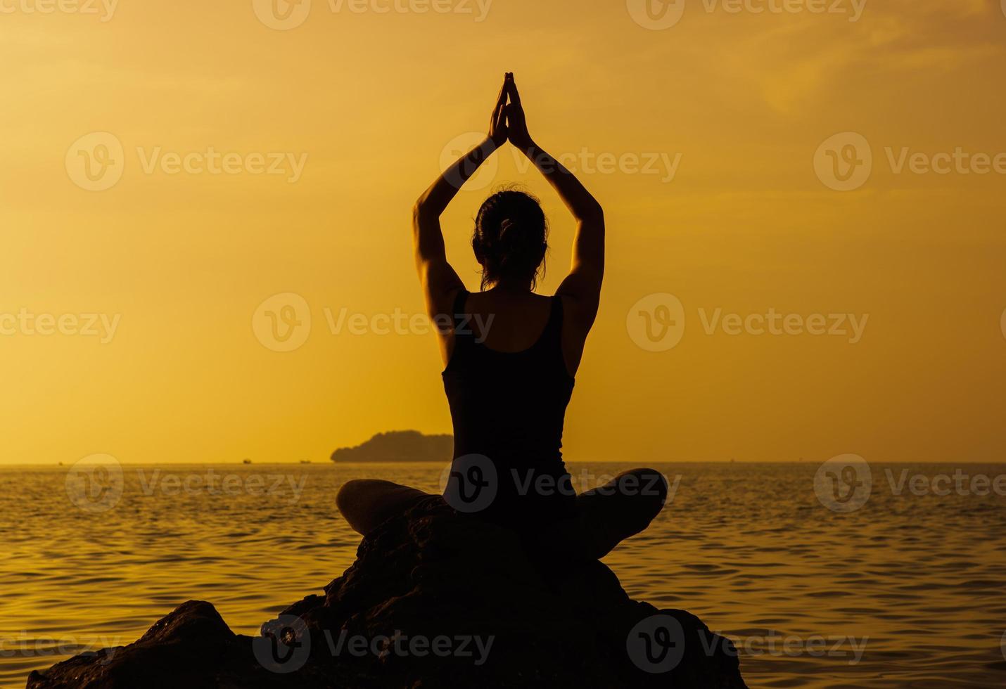 Woman meditation on sunset beach photo