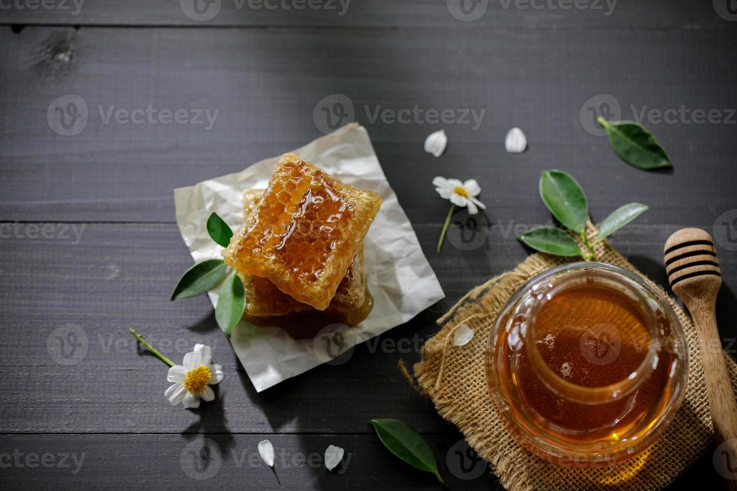 miel orgánica y panal en la mesa de madera, productos saludables por concepto de ingredientes naturales orgánicos foto