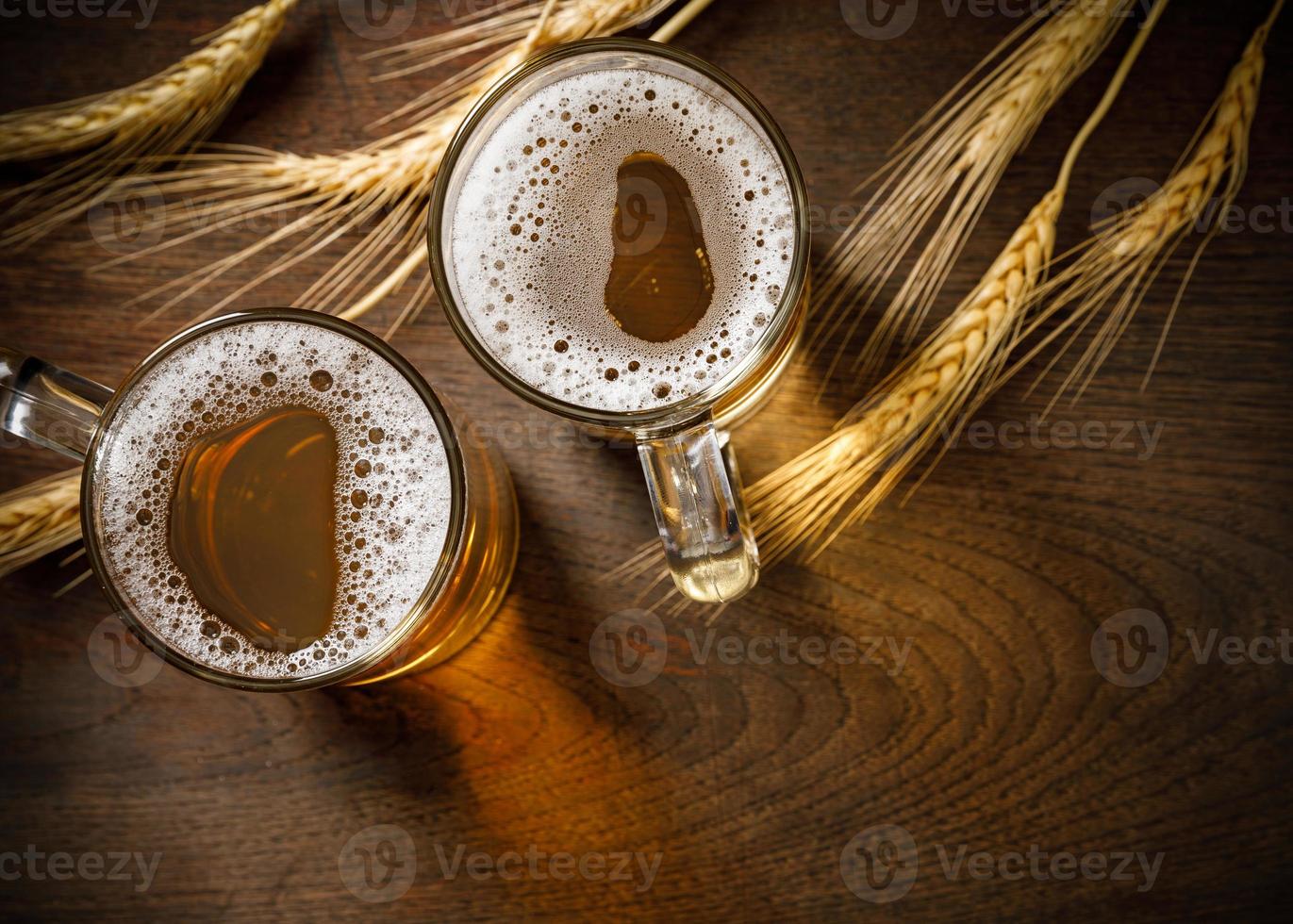 vasos de cerveza ligera con trigo en la mesa de madera, copie el espacio para su texto foto