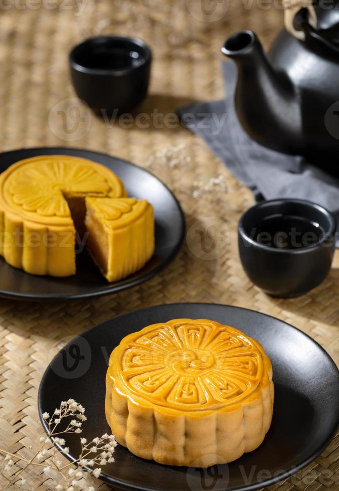 Moon cake with cup of hot tea on the the wooden table background with copyspace for your text, Asian traditional festival concept photo