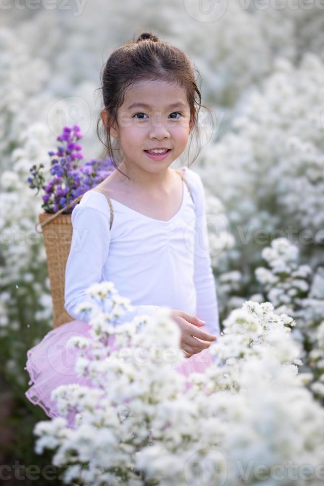 Cute little smiling girl wear a magic ballet fairy costume in beautiful white of margaret flowers field. photo