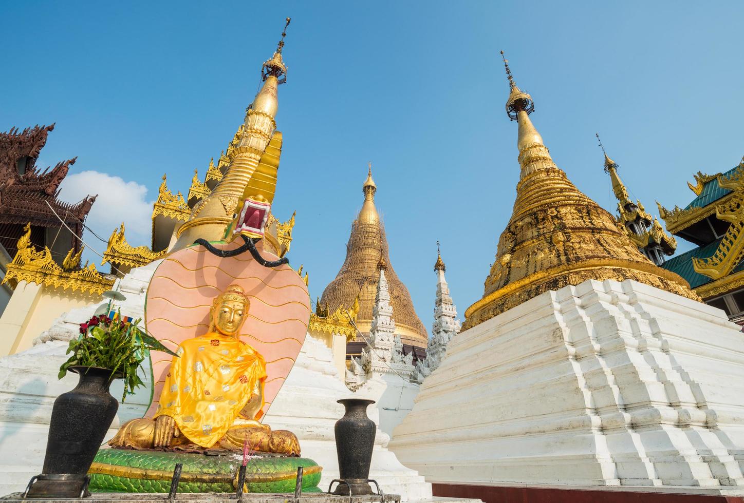 The Buddha statue and group of small pagoda in Shwedagon pagoda of Yangon township of Myanmar. Shwedagon Pagoda enshrines strands of Buddha's hair and other holy relics. photo