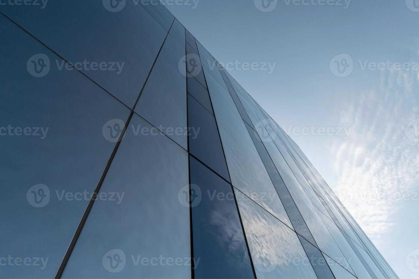Modern mirror wall decoration of business center, copy space. Bottom view to texture of exterior design. Contemporary pattern of buildings. Looking up. photo