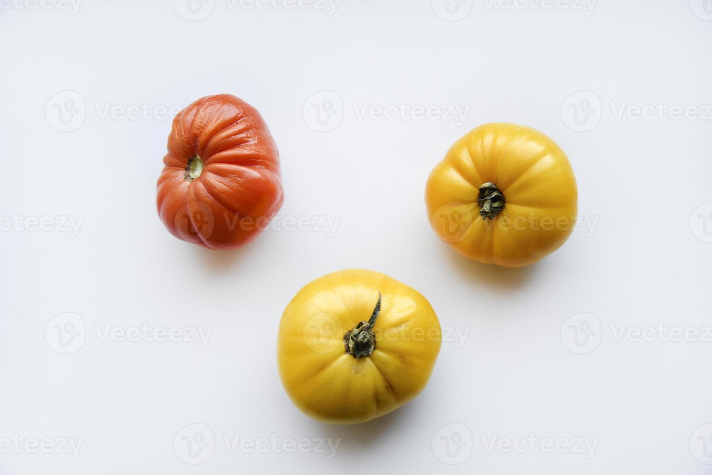 Yellow green and red tomatoes on a white background. Beautiful multicolored tomatoes close-up. photo