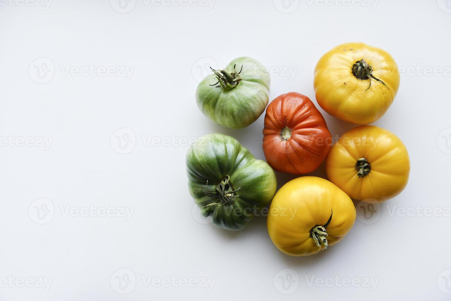 Yellow green and red tomatoes on a white background. Beautiful multicolored tomatoes close-up. photo