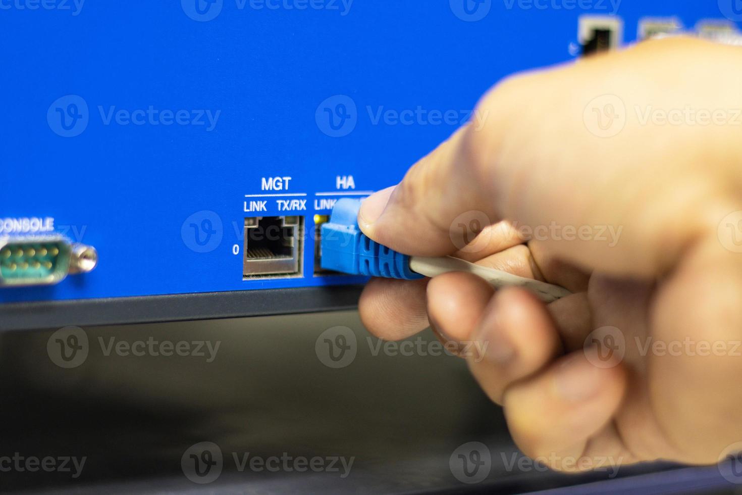 Hand of a man holding The network cables to connect the port of a switch to connect internet network, concept Communication technology photo