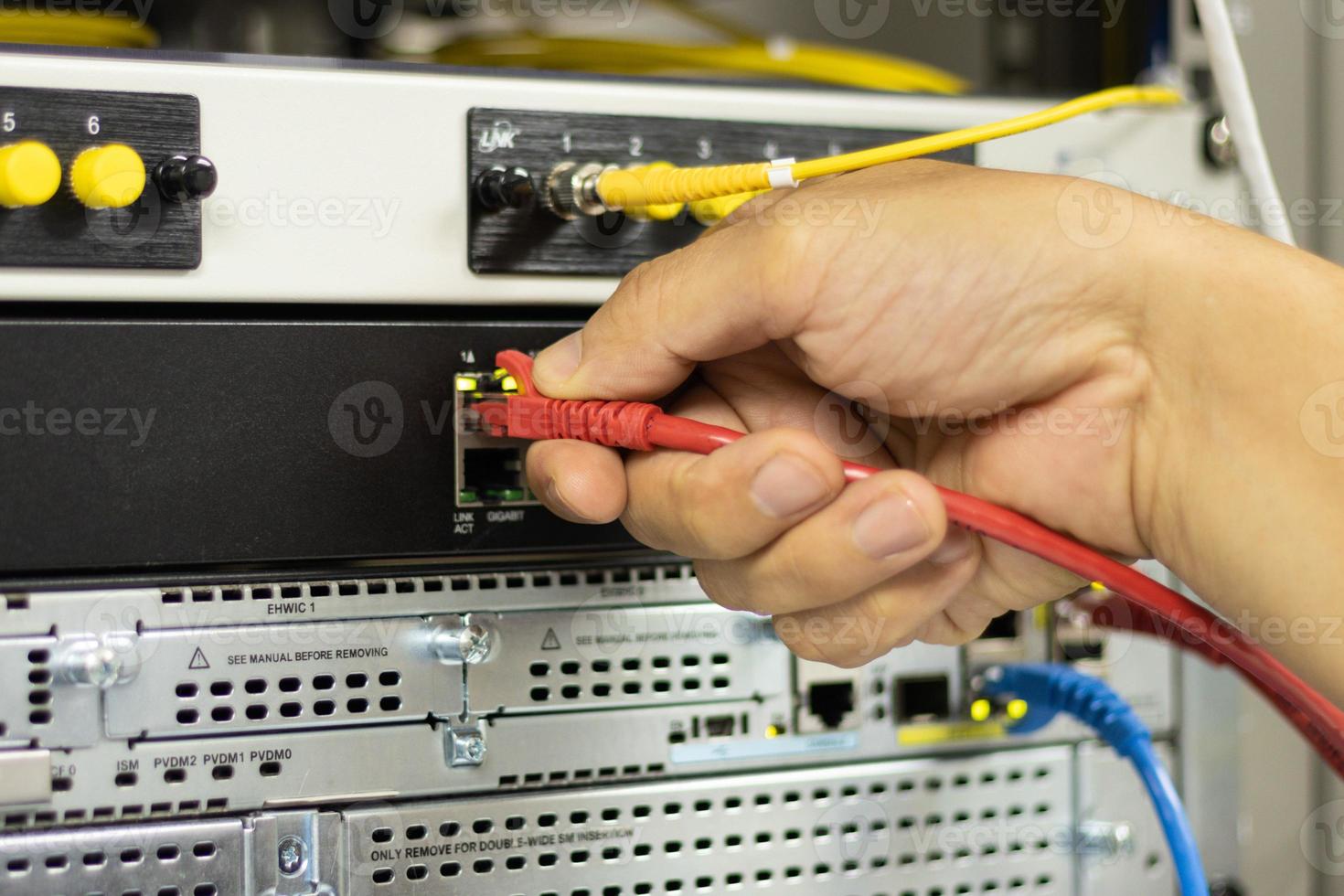 Hand of a man holding The network cables to connect the port of a switch to connect internet network, concept Communication technology photo