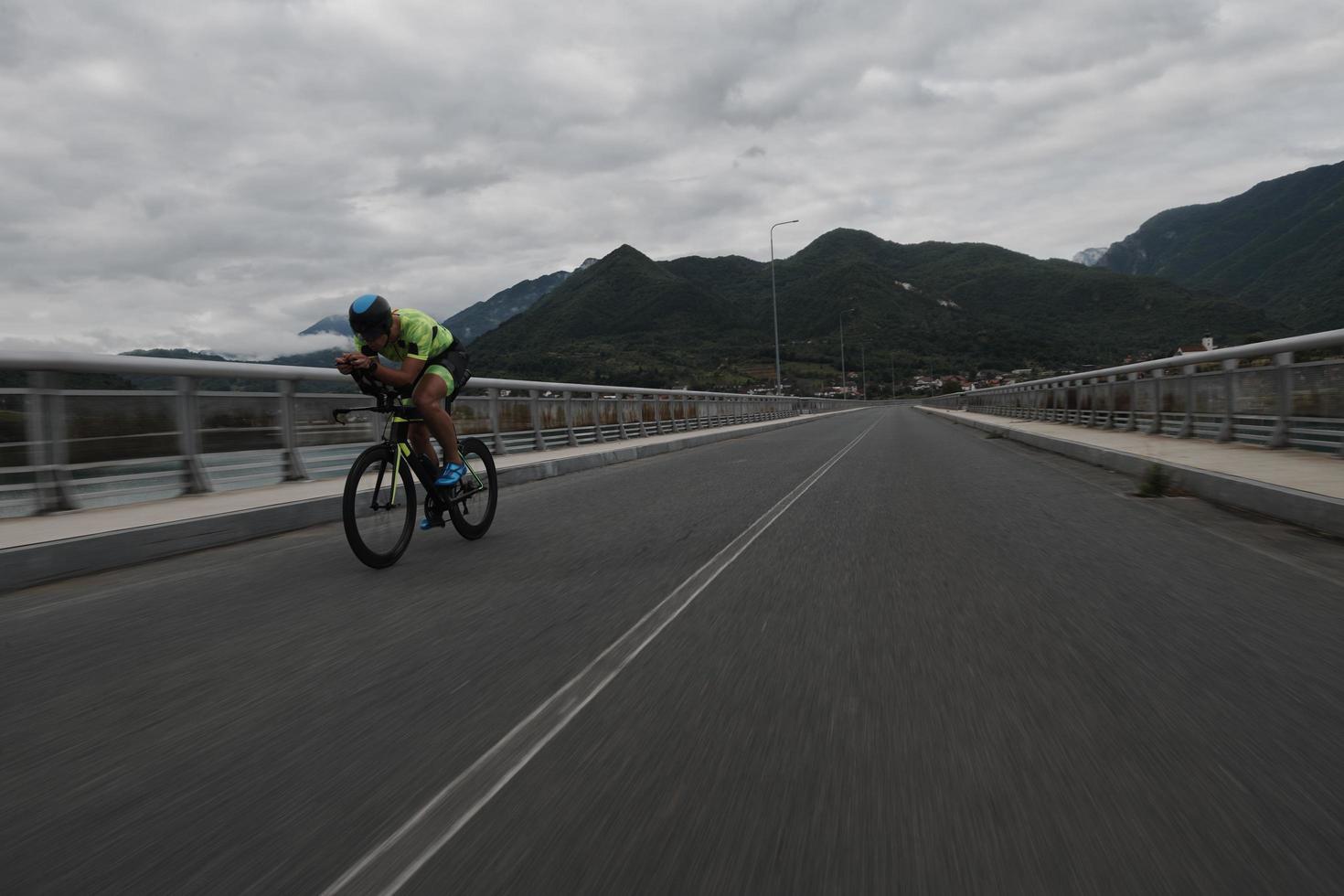 atleta de triatlón montando en bicicleta en el entrenamiento matutino foto