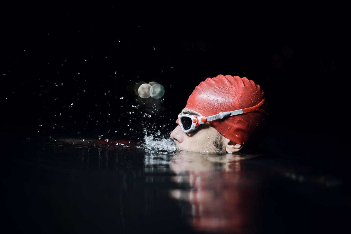 authentic triathlete swimmer having a break during hard training on night photo